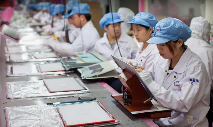 Workers assemble and perform quality control checks on MacBook Pro display enclosures at an Apple supplier facility in Shanghai.